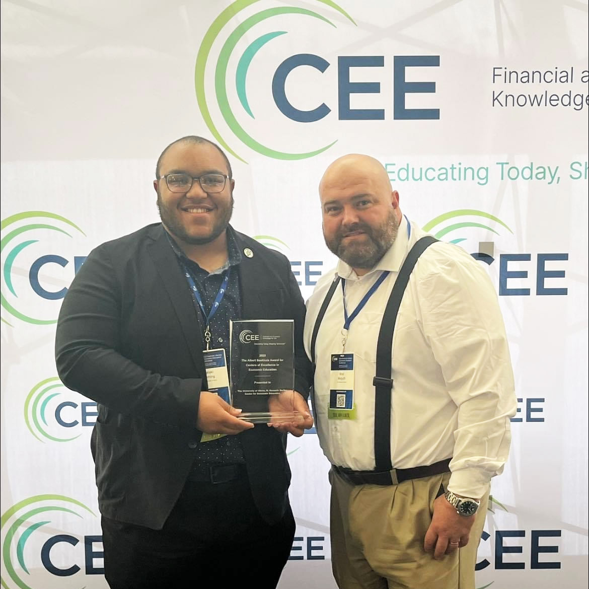 Two employees with the H.K. Barker Center posing with an award from the Council for Economic Education
