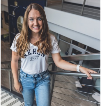 College of Business student, Sophia Marcum. Standing on the steps of the Anthony J. Alexander Professional Development Center staircase.