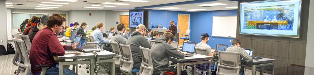 Students in a computer networking class listen to the professor
