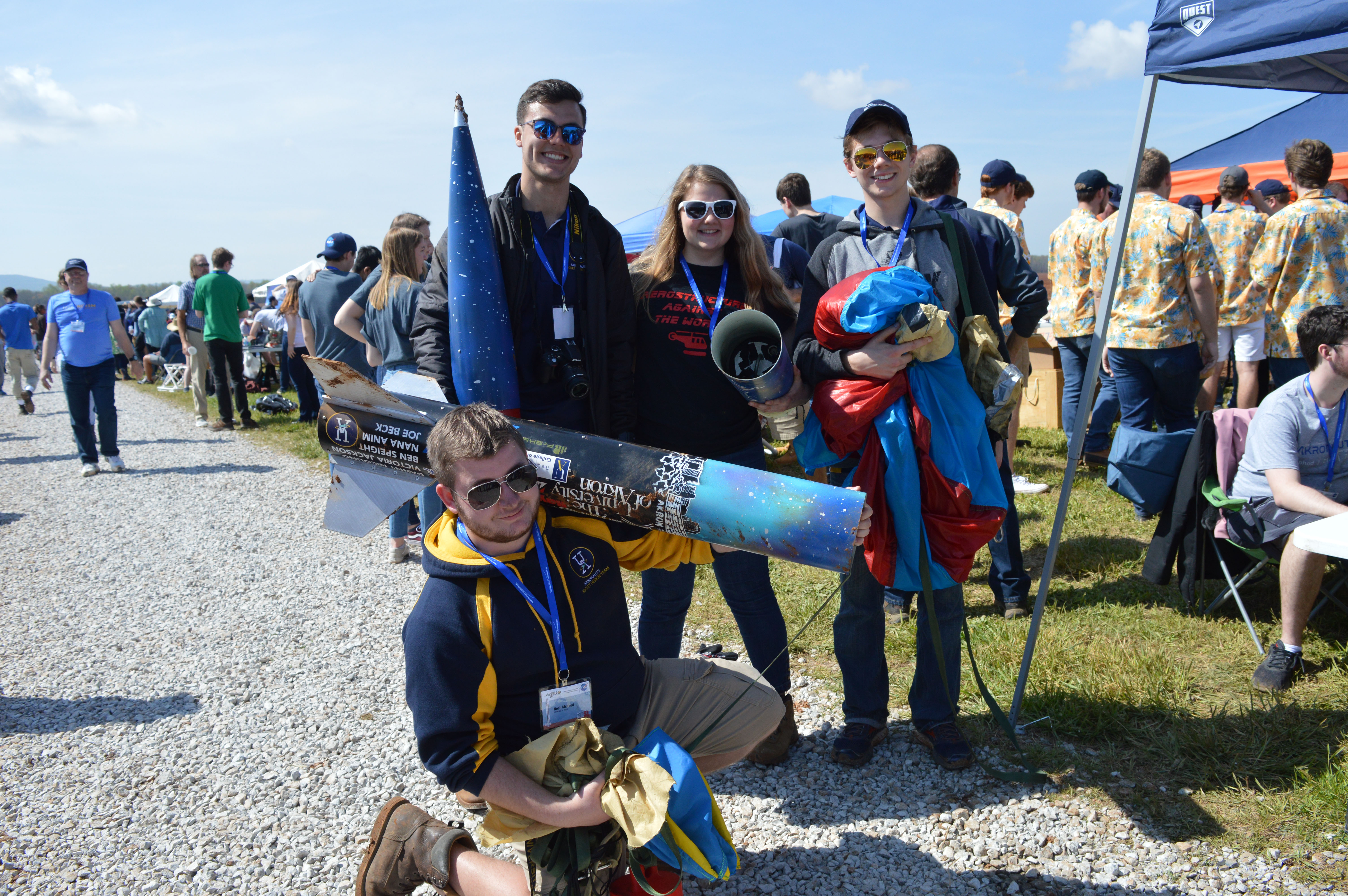 Members of the student rocket design team and the rocket they designed