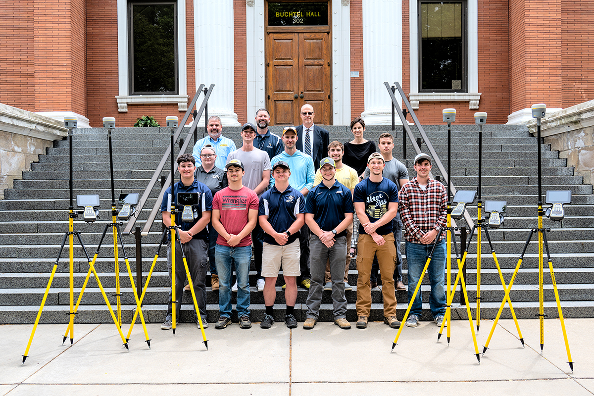 Mike Painter, Joseph Fenicle, Dean Craig Menzemer, Stephanie LaGuardia and Surveying and Mapping students stand in front of Buchtel Hall with the donated Global Navigation Satellite System equipment.
