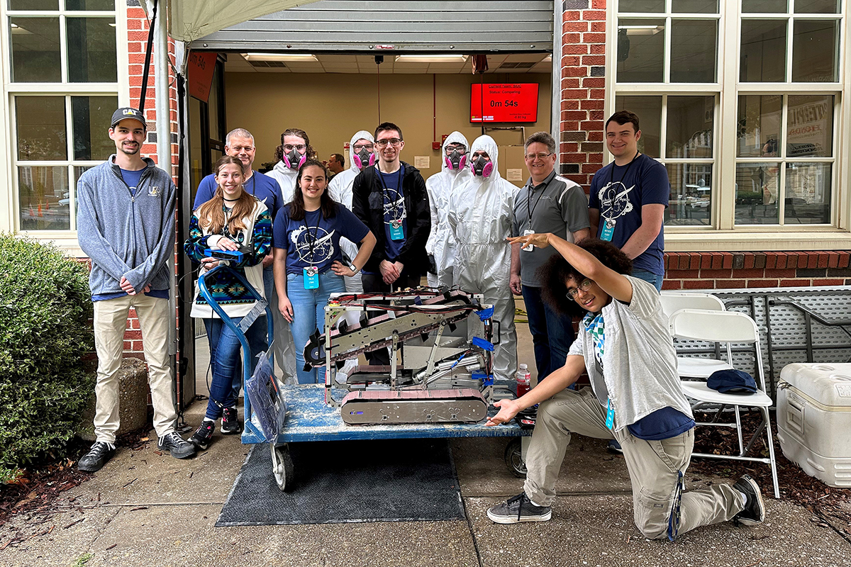 The team gathers outside the arena with their robot before a competition round.