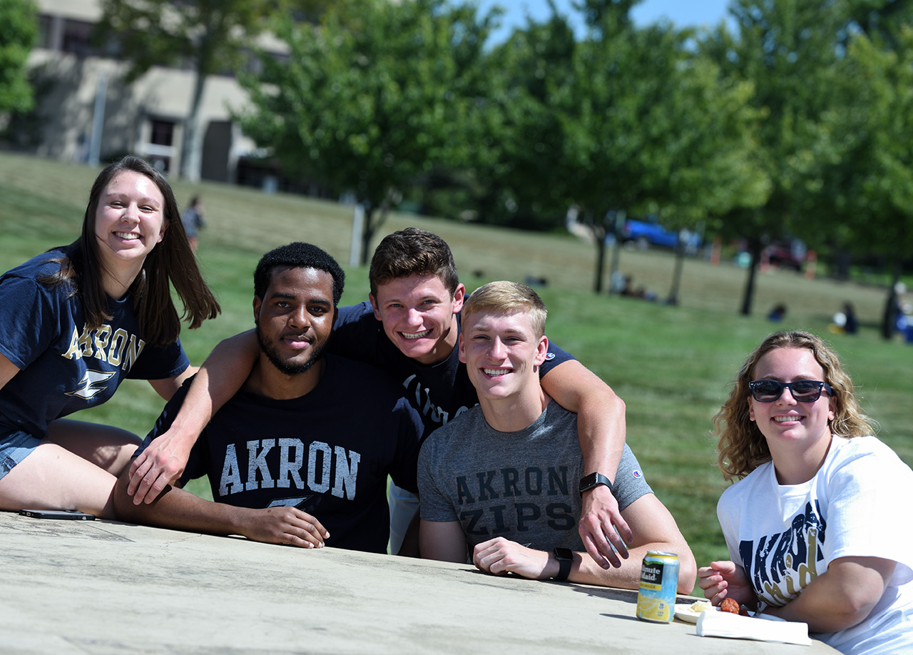 Diverse group of students sitting at a table on campus