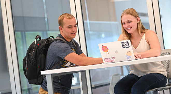 Two students working on a project in the business school