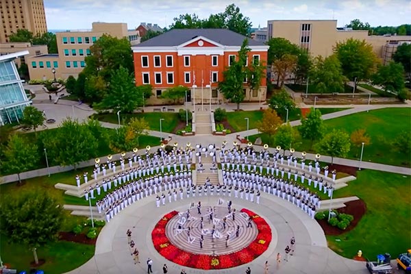 A park-like area of campus is covered with tents and students during New Roo Weekend
