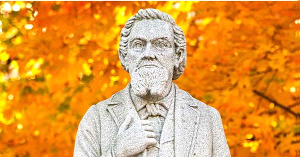 Statue of the university's founder with autumn leaves in the background