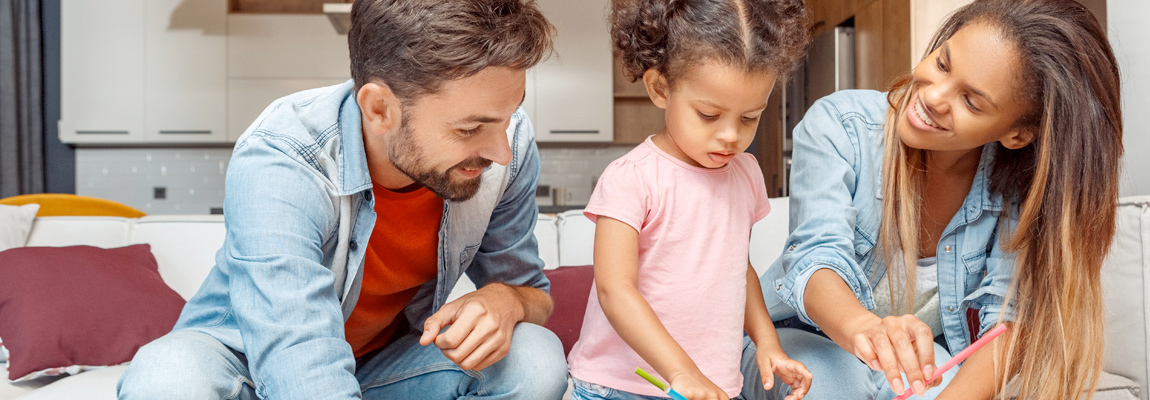 Two young parents playing with their young child.