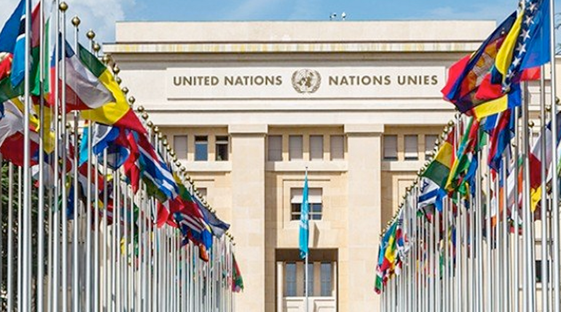 A government building with flags from multiple nations in front of it.