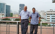 Two UA professors standing with a city skyline behind them